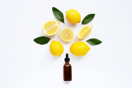 Essential oil with lemon and green leaves isolated on white background.