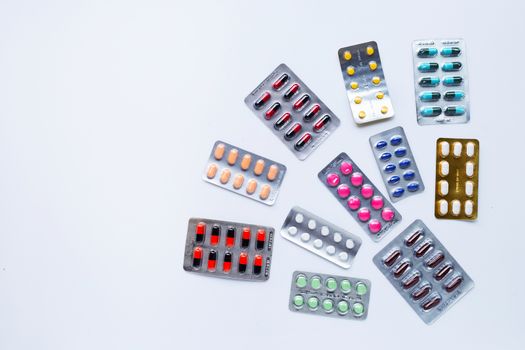 Various capsule medicines, pills and tablets in blister pack on white background.