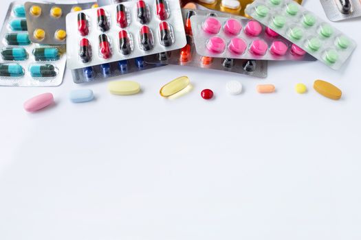Various capsule medicines, pills and tablets in blister pack on white background.