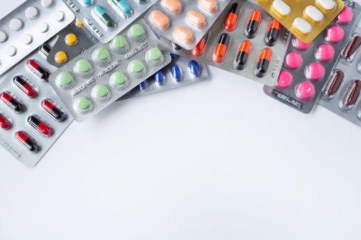 Various capsule medicines, pills and tablets in blister pack on white background. Copy space