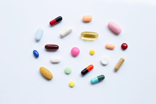 Colorful tablets with capsules and pills on white background.