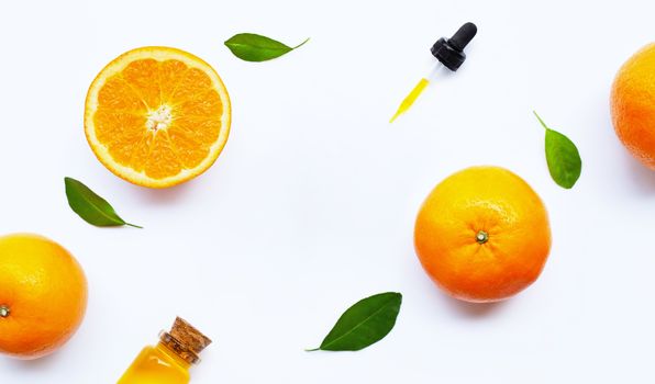 Essential oil with oranges on white background.