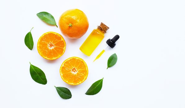 Essential oil with oranges on white background.