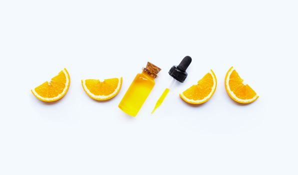 Essential oil with oranges on white background.