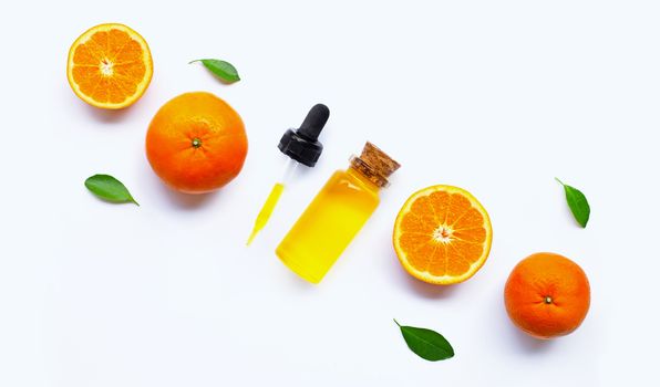 Essential oil with oranges on white background.