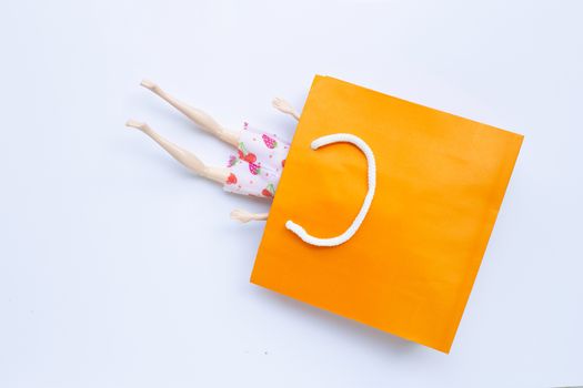 Woman doll  legs with paper shopping bag on white background. Copy space