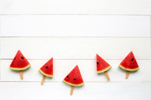 Watermelon slice popsicles on white wooden background. Copy space