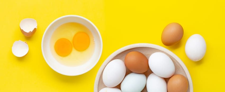 Fresh eggs on yellow background.  Top view