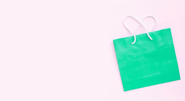 Paper shopping bag on pink background.