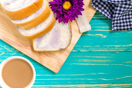 Taro bread with coffee for breakfast on vintage wooden background.