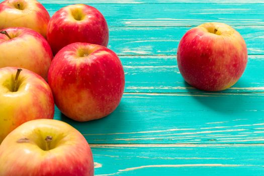 Group of red apple on blue wooden background.