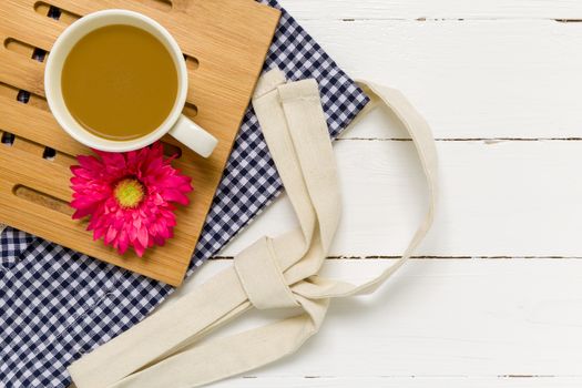 Relaxing break with coffee cup and white wooden background.