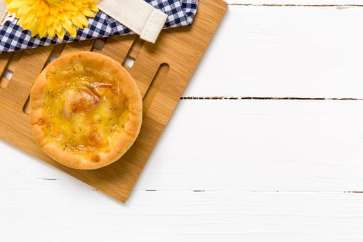 Fresh cheese bread with coffee cup on white wooden background.