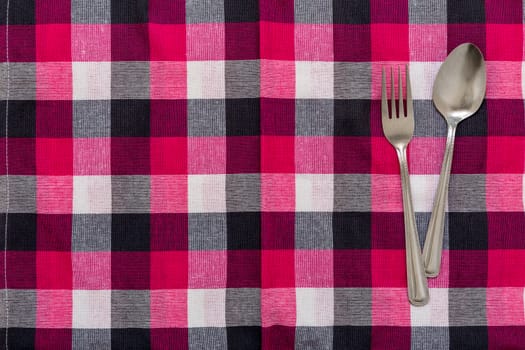 Spoon and Fork put together on table background.