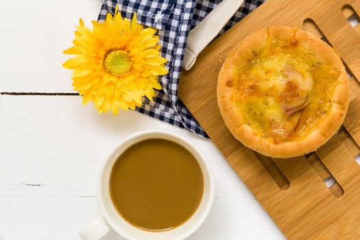 Fresh cheese bread with coffee cup on white wooden background.