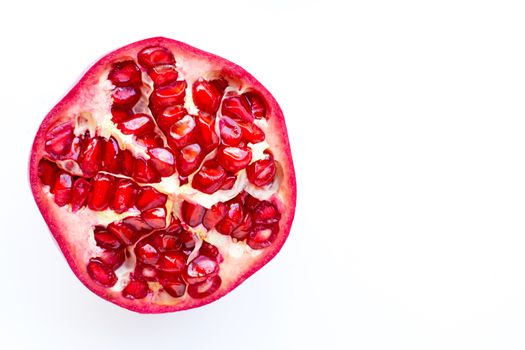 Top view of ripe pomegranate fruiton white background. Copy space