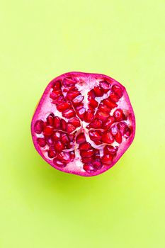 Top view of ripe pomegranate fruit on green background.