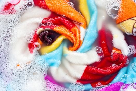 Colorful blanket soak in powder detergent water dissolution, washing  cloth. Laundry concept