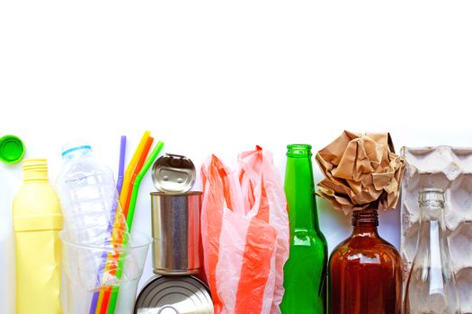 Recyclable garbage, plastic bottle, glass bottle, can and egg paper tray on brown plywood background. Copy space