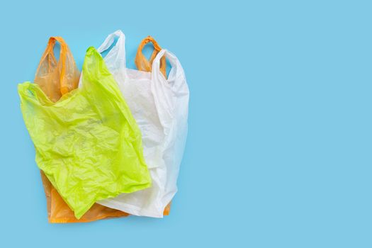 Colorful plastic bags on blue background. Copy space