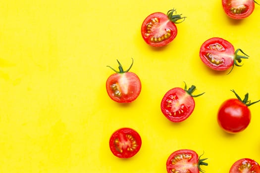 Fresh tomatoes, whole and half cut isolated on yellow background. Top view