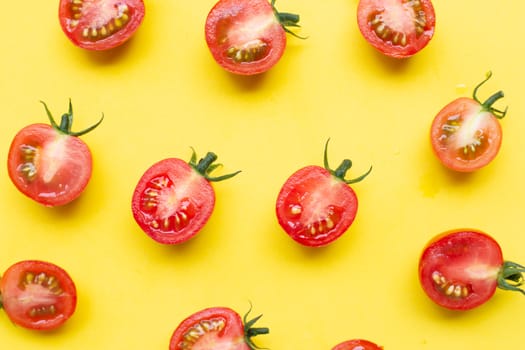 Fresh tomatoes, whole and half cut isolated on yellow background. Top view