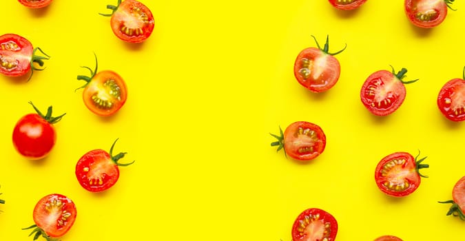 Fresh cherry tomatoes, whole and half cut isolated on yellow background. Copy space