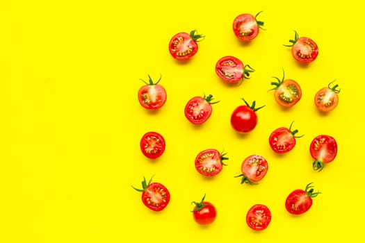 Fresh tomatoes, whole and half cut isolated on yellow background. Top view