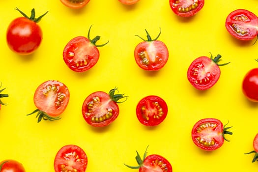 Fresh tomatoes, whole and half cut isolated on yellow background. Top view