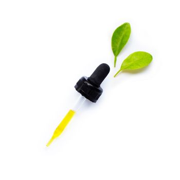 Essential oil in dropper with leaves isolated on white background.