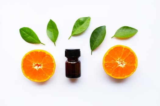 Orange essential oil with fresh fruits on white background