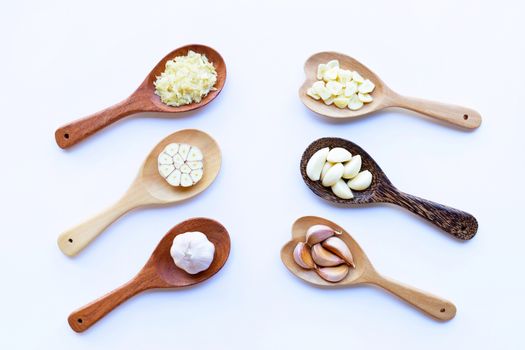 Garlic on wooden spoon on white background.