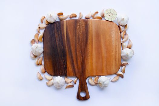 Garlic with wooden cutting board on white background.