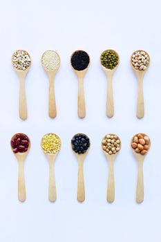 Different beans, legumes on wooden spoon on white background.