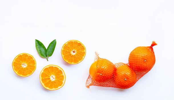 High vitamin C. Orange in net bag with ripe half of orange on white background. Copy space