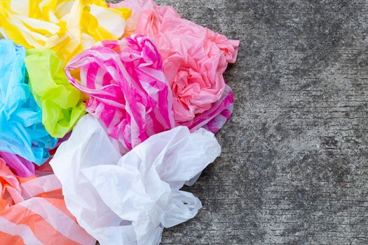 Colorful disposable plastic bags on cement floor 