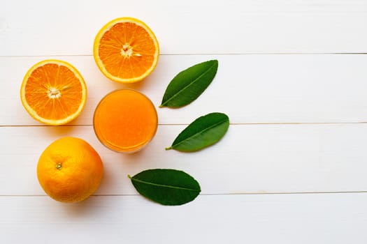 Fresh orange citrus fruit with leaves and Orange juice  on white wooden background