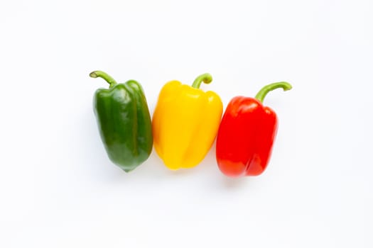 Green, yellow and red fresh bell pepper on white.