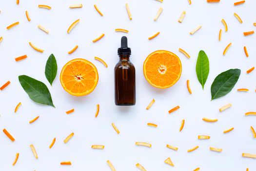 Essential oils with orange citrus fruits on white background.