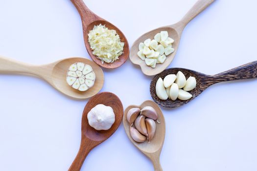 Garlic on wooden spoon on white background
