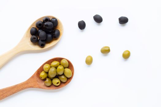 Olives on wooden spoon, white background. Top view