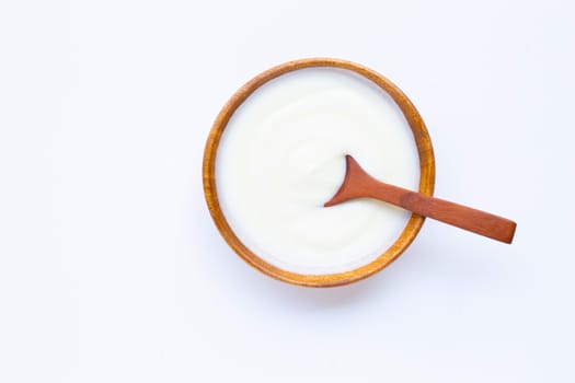 White yogurt in wooden bowl on white background.