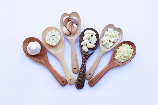 Garlic on wooden spoon on white background