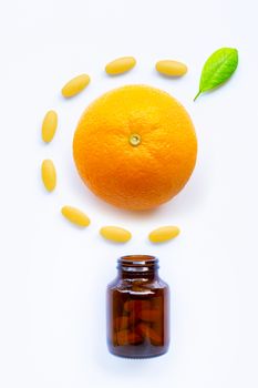 Vitamin C bottle and pills with orange fruit on white background