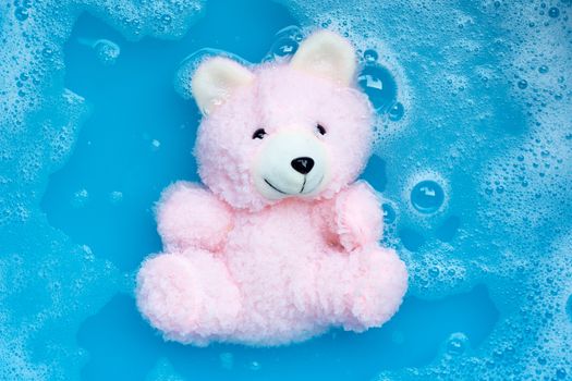 Soak  toy bear in laundry detergent water dissolution before washing.  Laundry concept, Top view