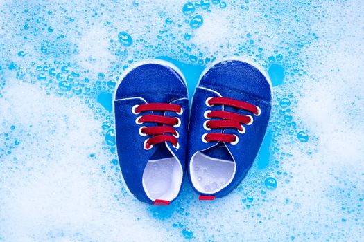 Soak baby shoes in baby laundry detergent water dissolution before washing.  Laundry concept, Top view