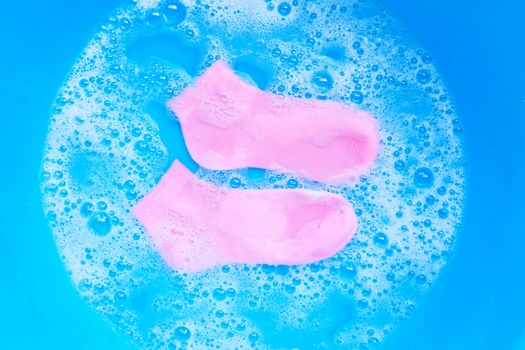 Pink  socks soaking in powder detergent water dissolution. Laundry concept. 