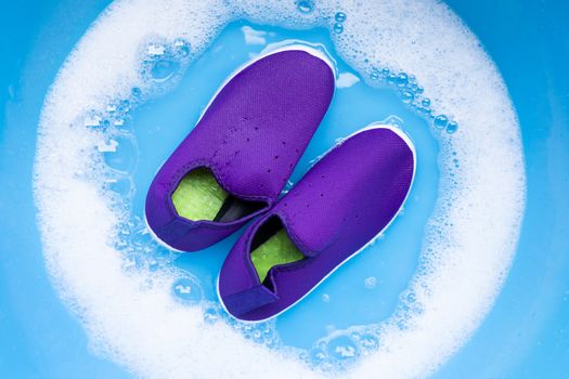 Soak  sneakers in laundry detergent water dissolution before washing.  Laundry concept, Top view