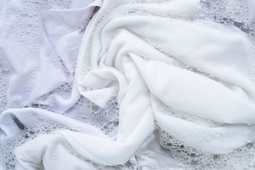 Soak white clothes in powder detergent water dissolution. Laundry concept