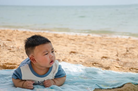 Cute baby boy Sleep on the cloth on the sand During clear weather